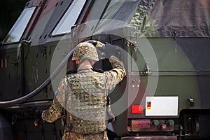 Soldier fuels a military armored truck