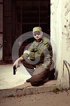 Soldier guarding building with pistol