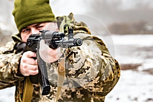 A soldier with a gun AKM, aims at the enemy. Barrel and muzzle machine close up