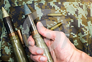 Soldier hold Bullets, shells, cartridges and projectiles on khaki camouflage backpack. Lend-Lease concept. Army concept. Sales of