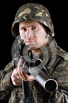 Soldier holding a gun in studio