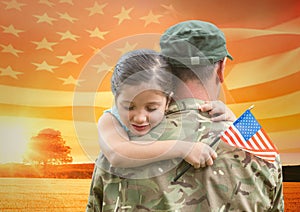 soldier hugging daughter in the field with usa flag