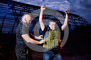 Soldier and instructor at night outdoors. A short man paratrooper and a large brutal male instructor during a military exercise