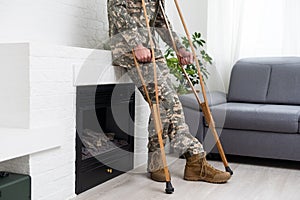 soldier in khaki military uniform on crutches