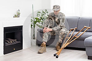 soldier in khaki military uniform on crutches