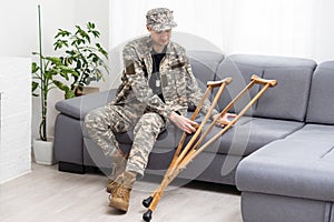 soldier in khaki military uniform on crutches