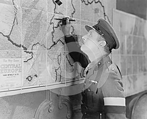 Soldier looking at a map marking it with a pen