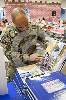 Soldier looks at Visions of America book at Christmas dinner, Wounded Warrior Center, Camp Pendleton, North of San Diego