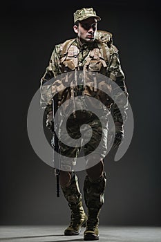Soldier man hold Machine gun on a dark background