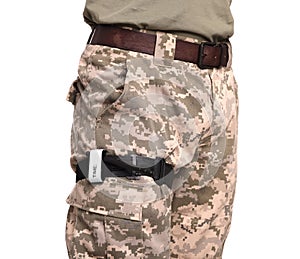 Soldier in military uniform with medical tourniquet on leg against white background, closeup