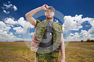 Soldier in military uniform over sky background