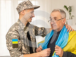 Soldier in military uniform reunited with his family and Ukrainian flag