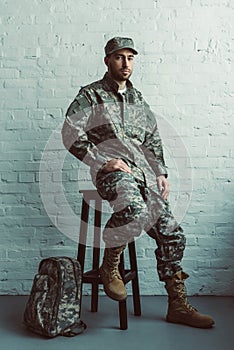 soldier in military uniform sitting on chair against white