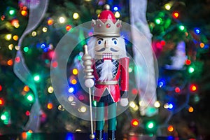 Soldier nutcracker statue standing in front of decorated Christmas tree