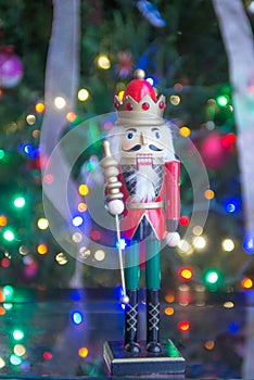 Soldier nutcracker statue standing in front of decorated Christmas tree