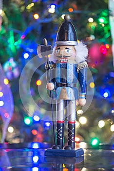 Soldier nutcracker statue standing in front of decorated Christmas tree