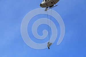 Soldier rescue emergency by army helicopter with rope on blue sky