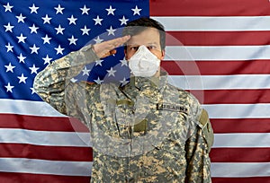 A soldier in a respirator salutes. American soldier salutes, wearing a protective mask against COVID-19