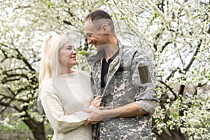 Soldier reunited with wife in park.