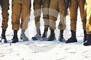 The soldier`s footwear of the Israeli army which is put on legs in clear sunny day.