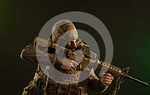 Soldier-saboteur in military clothing with weapons on a dark background