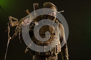 Soldier-saboteur in military clothing with weapons on a dark background