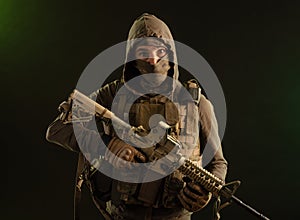 Soldier-saboteur in military clothing with weapons on a dark background