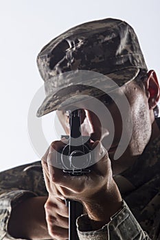 Soldier taking aim with assault rifle, vertical