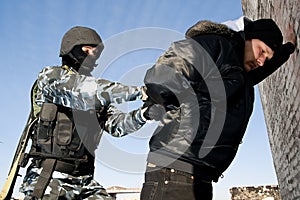 Soldier taking a criminal under arrest photo