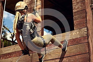 Soldier training rappel with rope. Military woman does hanging on climbing equipment