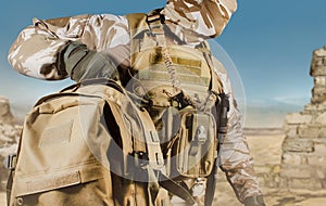 Soldier in uniform walking with backpack in desert