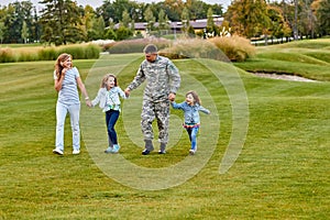 Soldier walking with kids and wife.