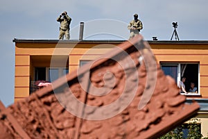 Soldiers with binoculars on the top of the building