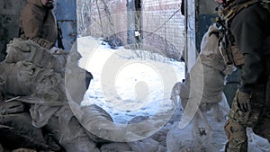 Soldiers in camouflage with combat weapons sneak along the corridors of the old building, the military concept