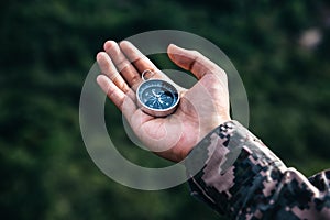 Soldiers holding compass for determines the location