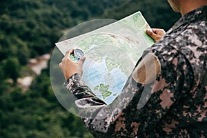 Soldiers holding compass and map for determines the location