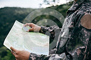 Soldiers holding compass and map for determines the location