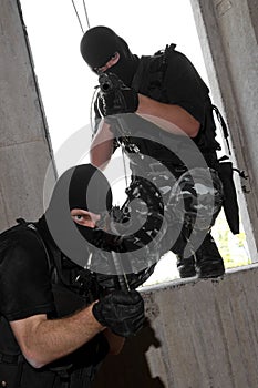 Soldiers in masks entering the window with rifles