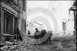 Soldiers walking through bombed out building