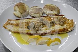 Sole fish with Canarian potatoes and capers sauce, seafood dish with a tasty flavorsome fish, papas arrugadas and sauce