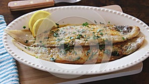 Sole meuniÃ¨re fish on a wooden board