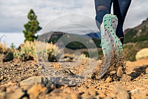 Sole of shoe walking in mountains on rocky footpath