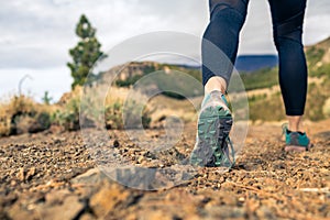 Sole of shoe walking in mountains on rocky footpath