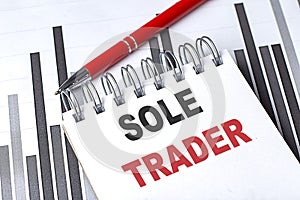 SOLE TRADER text written on notebook with pen on chart