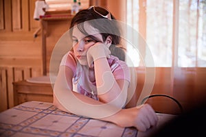 Solemn girl at table