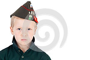 Solemn young caucasian boy playing dress up wearing folding army hat - pilotka - from Soviet Red Army