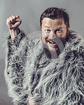 Solid bearded man in a fur mantle studio emotional