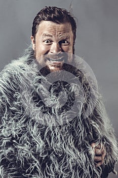 Solid bearded man in a fur mantle studio emotional