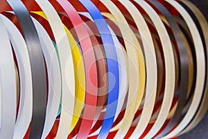 Solid color or wood grain PVC edge banding tape. ABS edge banding. Set of colored thermoplastic edges. Multicolored bobbins of PVC