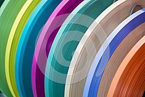 Solid color or wood grain PVC edge banding tape. ABS edge banding. Set of colored thermoplastic edges. Multicolored bobbins of PVC